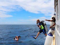 divers-jumping-into-crystal-clear-Maldives-sea-from-diving-dhoni